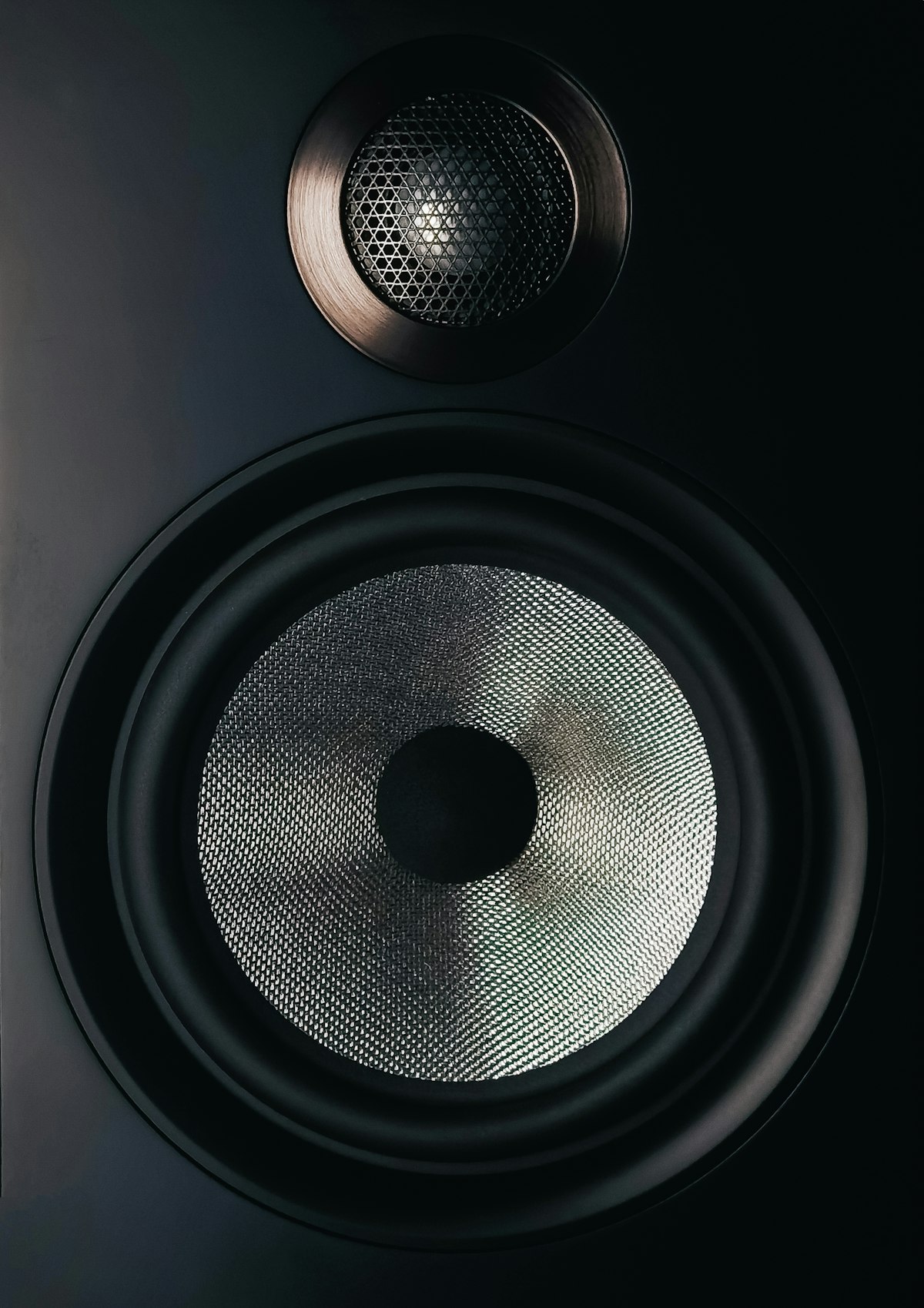 Close-up of a speaker driver on a wooden table
